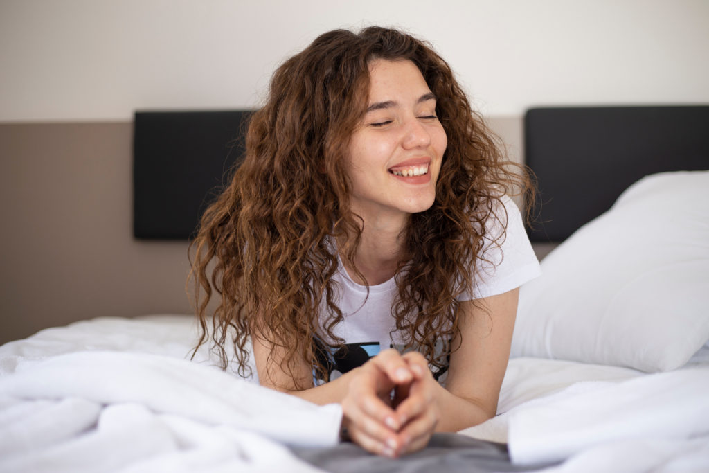 Young girl laughing in bed